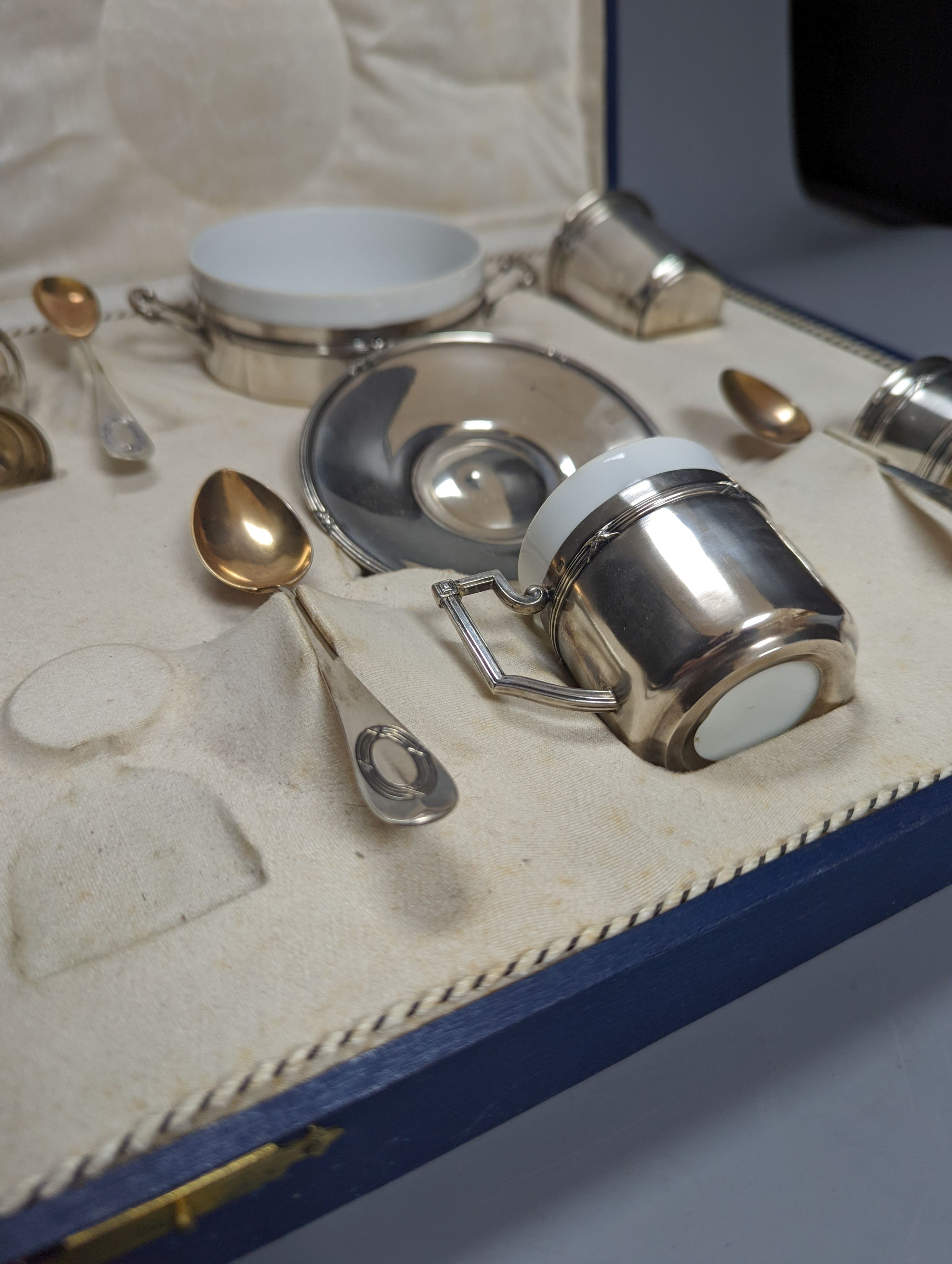 A cased part German 800 white metal mounted ceramic part tea set (incomplete), metal weight 5.5oz.